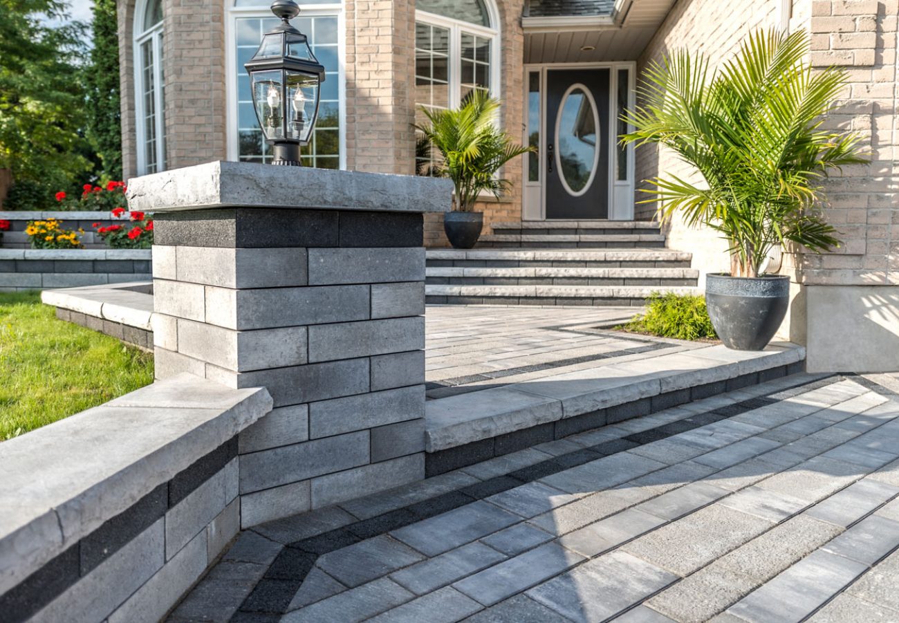 Unilock Front Entrance with Retaining Wall and Pillar at Entrance of Walkway connected with Steps