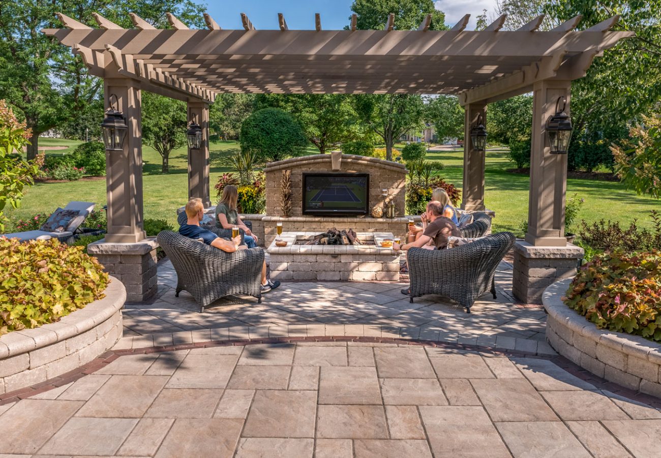 People Gathered on Unilock Patio around Outdoor Fire Pit watching TV