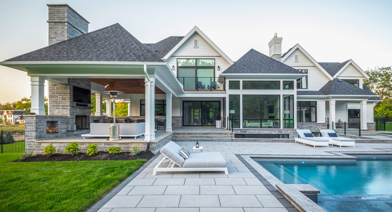 Extended Indoor Outdoor Patio Space by Pool with Tall Fireplace feature and TV wall