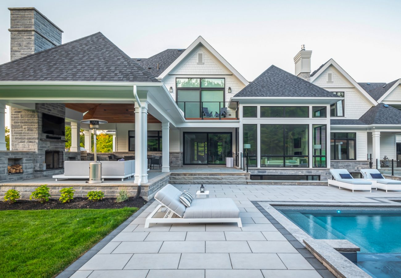 Extended Indoor Outdoor Patio Space by Pool with Tall Fireplace feature and TV wall