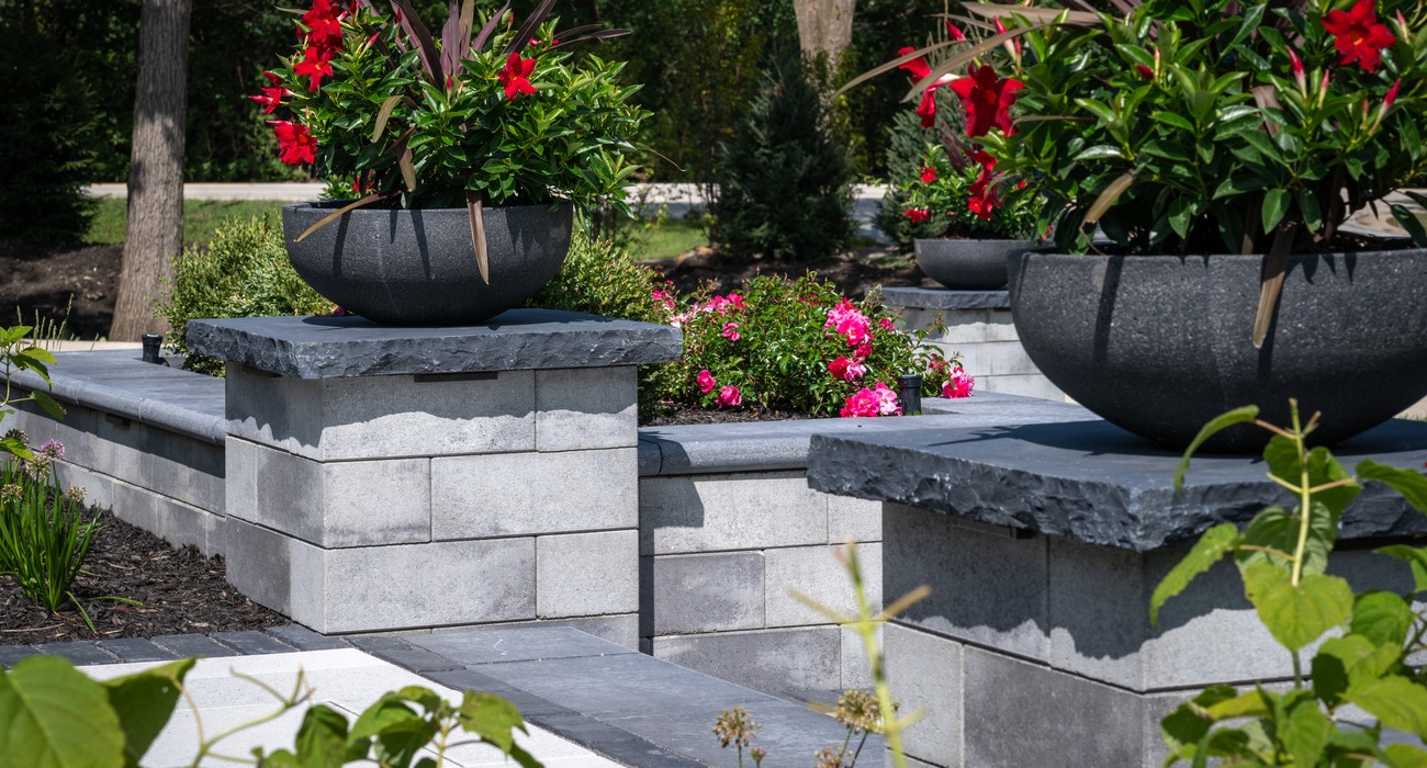 Potted planters atop Unilock Pisa pillars